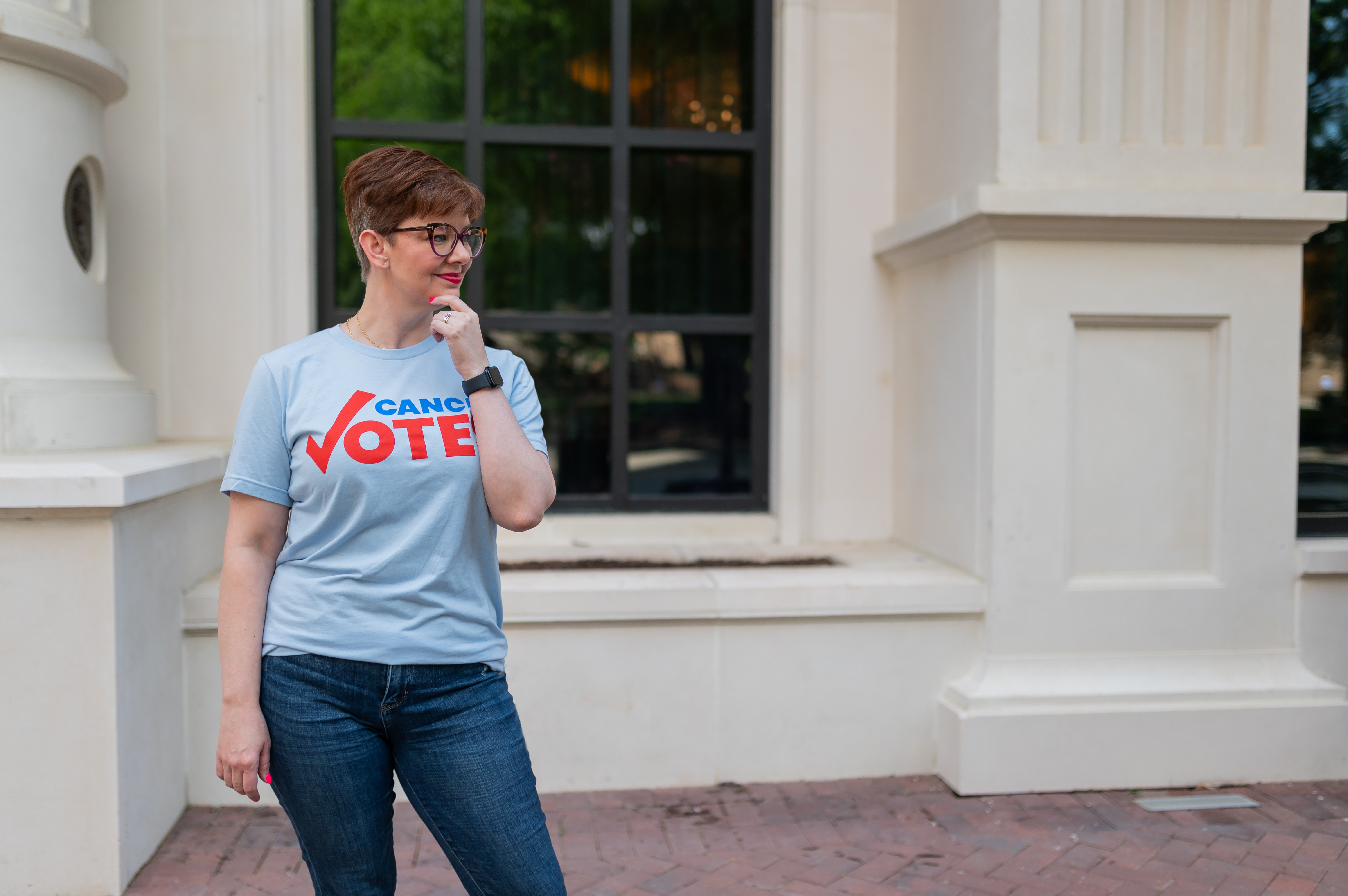 A woman wearing a Cancer Votes blue shirt with her hand on her chin