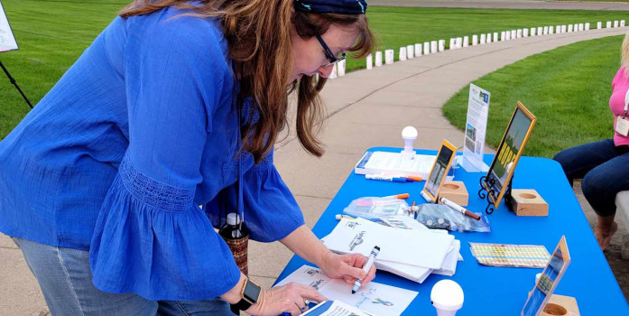 Volunteer making Lights of Hope at a Table