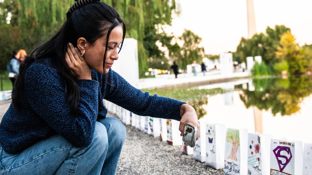 Woman taking a photo of lights of hope bags