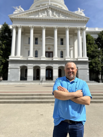 ACS CAN volunteer Cesar Serrano stands in front of the California Capitol.