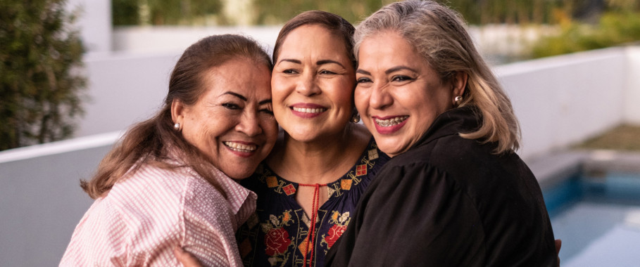 Female latin friends hugging and laughing