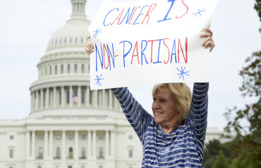 Volunteer holding a sign that reads "Cancer is non partisan"