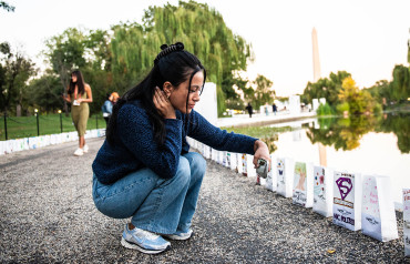 Woman taking a photo of Lights of Hope bags